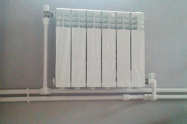 радиатор отопления с подключенными трубами из полипропилена